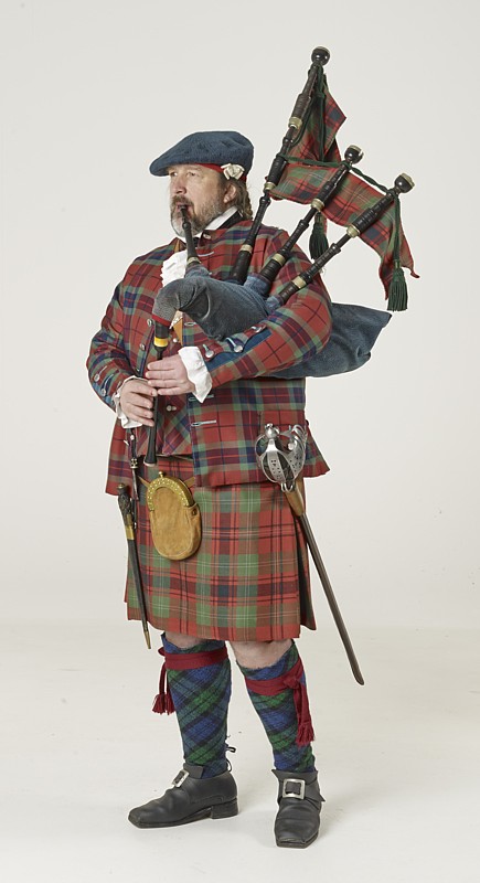 Quest in historischer Hochland-Tracht im Kilt mit Tartan-Jacke, die Highland-Bagpipe spielend